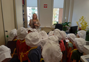 Przedszkolaki w sekretariacie częstują P. Anię.